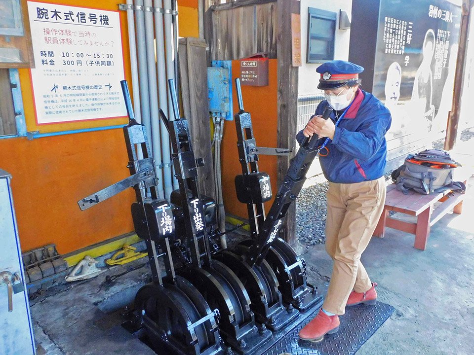 腕木式信号機のレバーを操作する駅員＝恵那市岩村町、明知鉄道岩村駅