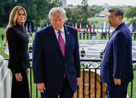 　ホワイトハウスのバルコニーを後にするトランプ米大統領（中央）と中国の習近平国家主席（右）＝２４日、ワシントン（ロイター＝共同）