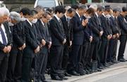 　尼崎ＪＲ脱線事故の発生時刻に合わせ、現場付近で黙とうする人たち＝２５日午前９時１８分、兵庫県尼崎市
