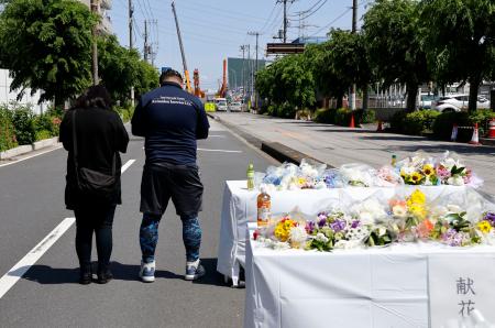 　県道陥没事故の現場周辺の献花台で手を合わせる近隣住民ら＝３日午後、埼玉県八潮市