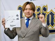 　契約更改を終え、来季の目標を書いた色紙を手にポーズをとるオリックスの宮城＝１８日、大阪市
