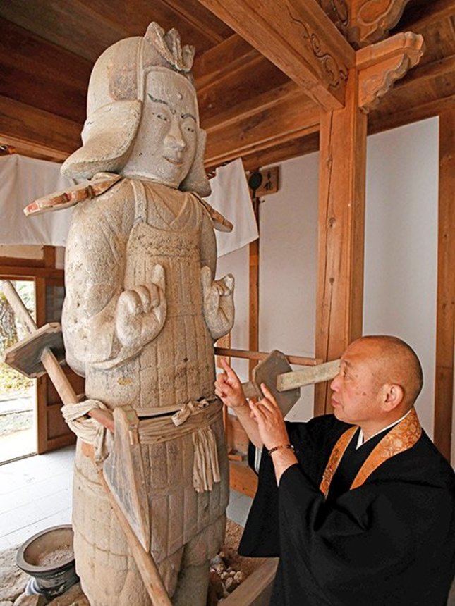 両面宿儺の石像。大下大圓住職は、手の形は仏が結ぶ「印」と解説する＝高山市丹生川町下保、千光寺