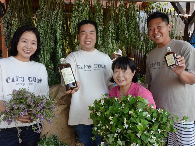 揖斐川町春日地区で採れた薬草を使用した「ぎふコーラ」を手にするメンバーら＝揖斐川町上南方、キッチンマルコ