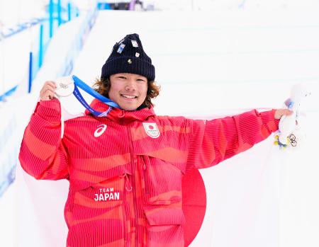 　男子スロープスタイルで獲得した銀メダルを掲げる長谷川帝勝＝リビーニョ（共同）