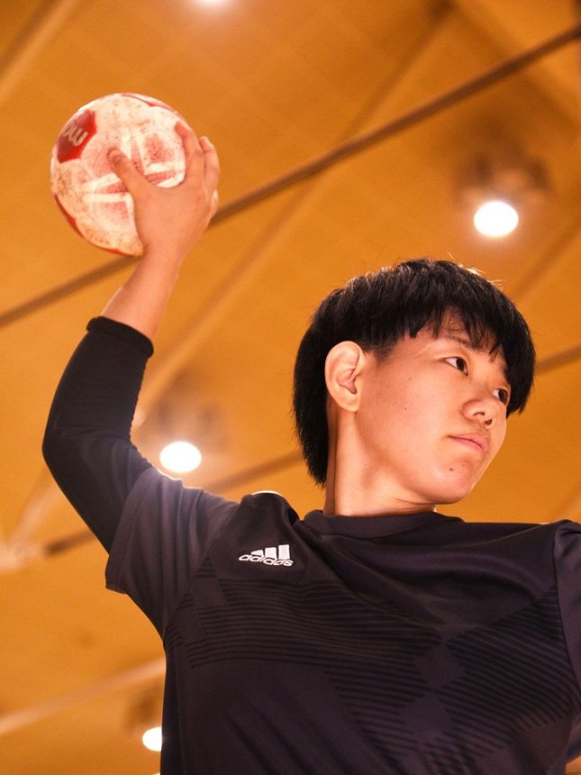 豊島梨奈主将にシュートを決める時の構えを見せてもらった。ボールをつかみ、手首をひねってゴールへと投げる＝高山市中山町、飛騨高山ビッグアリーナ