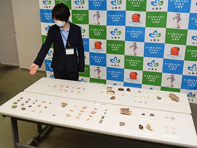 台所と曲輪群の調査で出土した玉石や陶磁器片など＝山県市役所