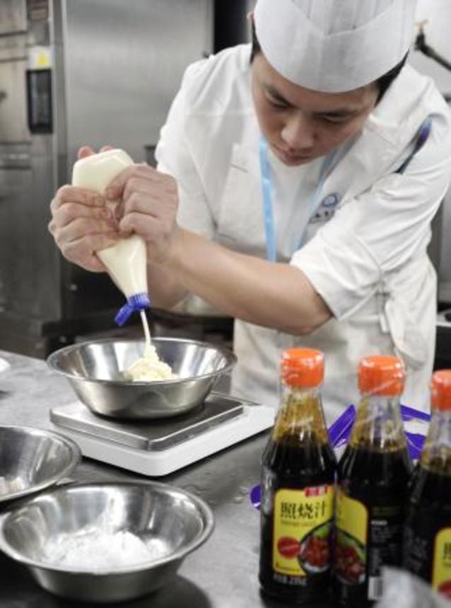 　日本のマヨネーズを使って広東料理を作るコック＝２８日、中国・広州（共同）