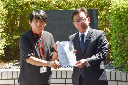 　全国薬害被害者団体連絡協議会の花井十伍さん（左）から要望書を受け取る上野厚労相＝２４日午後、厚労省