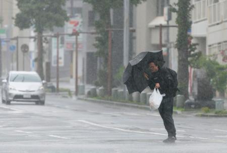 　台風６号の影響で風雨が強まる鹿児島市内を歩く男性。３日にかけて西日本から東日本の太平洋側に近づく恐れがある＝２日午前