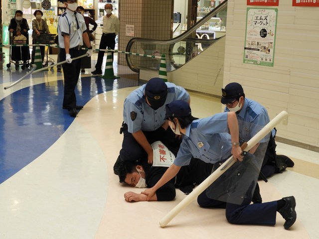 不審者役を取り押さえる署員＝岐阜市正木中、マーサ２１