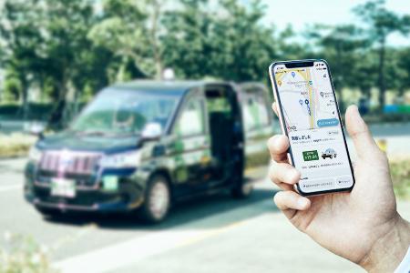 　「ＧＯ」が展開するタクシー配車アプリのスマートフォン画面（手前）と対応車両