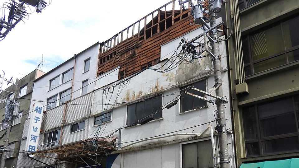 外壁の一部が剝がれ落ちたビル＝２０日午後０時１８分、岐阜市問屋町
