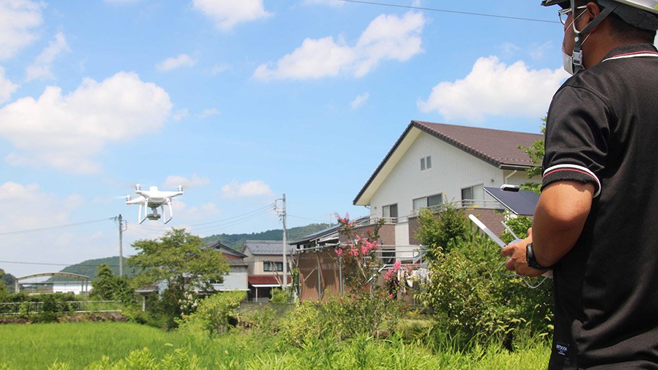 センシング用ドローンを飛ばす青木友誉社長＝御嵩町内