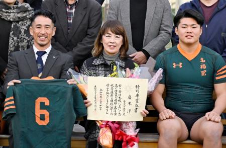 　広木淳さんに授与された特別卒業証書を手に記念撮影する母ますみさん（中央）。左はラグビー部のチームメートだった山下昂大さん＝１１日午後、福岡市の東福岡高