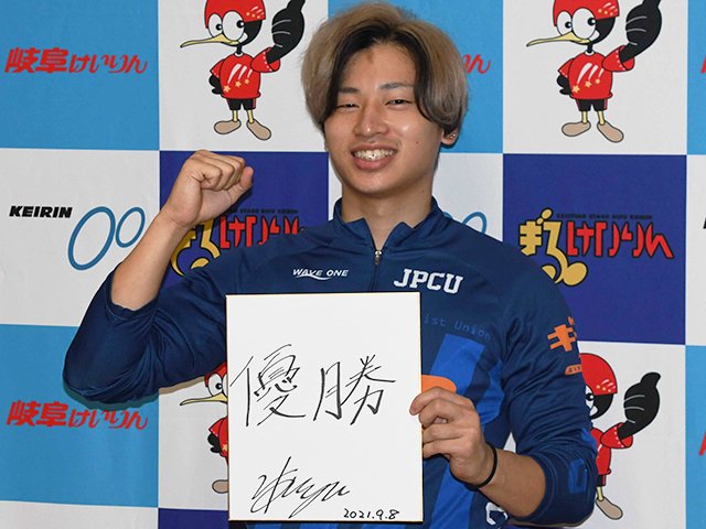色紙に抱負を「優勝」と記し、ポーズを取る山口拳矢＝岐阜競輪場