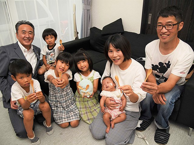 石田仁市長（左端）から贈呈されたスプーンを手にする中村さんファミリー＝大垣市木戸町