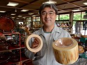 間伐材のヒノキを使ったペットテーブルをＰＲする大蔵衛社長＝中津川市駒場、大蔵木工所
