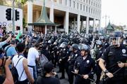 　米ロサンゼルスの連邦庁舎近くで、警察官と向き合う抗議デモ参加者＝９日（共同）