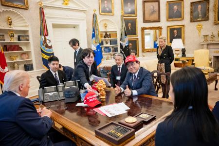 　ホワイトハウスで開かれたトランプ米大統領（手前左）との会談でＭＡＧＡ帽子をかぶった赤沢経済再生相＝１６日、ワシントン（ホワイトハウス提供、共同）