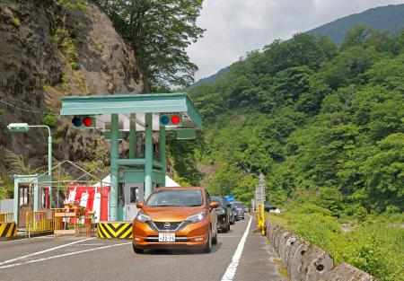 　全線開通した「白山白川郷ホワイトロード」の料金所を通る車＝１２日午前、石川県白山市