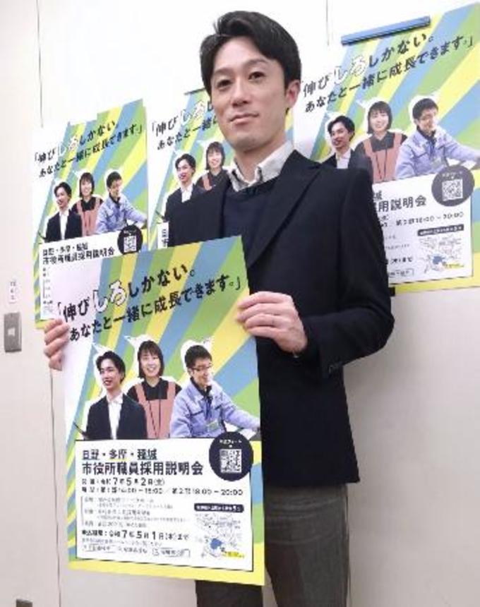 　東京・多摩地域の３市合同採用説明会のポスターを持つ日野市の職員＝１７日、日野市役所