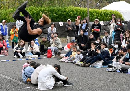 　「大道芸ワールドカップｉｎ静岡２０２５」で、座った子どもたちの上を宙返りで飛び越えるアーティスト＝３１日午後、静岡市