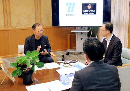 　イチゴの苗を前に、事業について説明する九州電力の西山勝社長（左）＝２５日午前、大分県庁