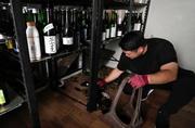 　地震の影響で割れた瓶を片付ける酒屋の店員＝２９日午後３時５０分、熊本県八代市