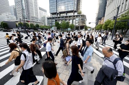 　東京・丸の内を歩く人たち＝７月