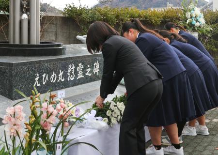 　えひめ丸事故から２５年となり、「追想の日」式典で慰霊碑に献花する宇和島水産高の生徒ら＝１０日午前、愛媛県宇和島市