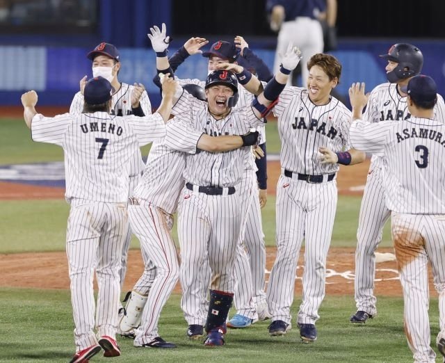 タイブレーク延長の末に米国にサヨナラ勝ちし、決勝打を放った甲斐（中央）と喜ぶ日本ナイン＝横浜スタジアム