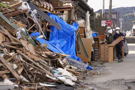 　能登半島地震で被災した家屋から家財道具を運び出すボランティア＝２０２４年２月、石川県輪島市