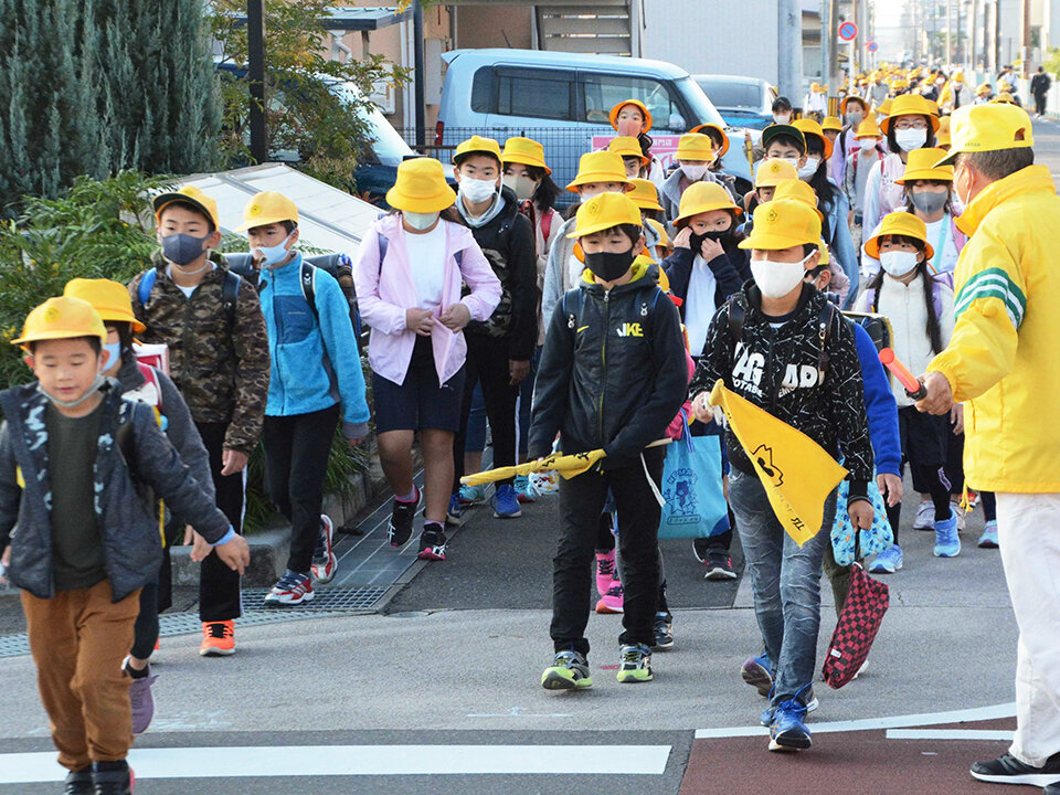 地域のボランティアに見守られて通学路を進む子どもたち＝岐阜市今嶺