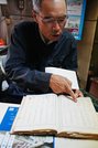 昭和から平成初期にかけての帳簿を見る出立浩之さん＝京都府舞鶴市