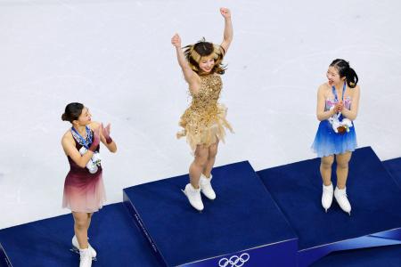 　女子の表彰式で喜ぶ優勝したアリサ・リュウ。左は２位の坂本花織、右は３位の中井亜美＝ミラノ（共同）