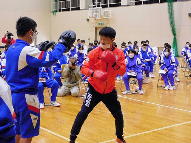 生徒を相手にパンチを披露する田中亮明選手＝恵那市山岡町、山岡中学校