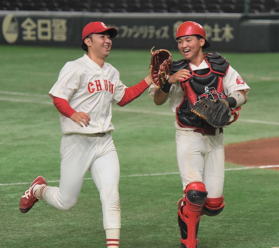 天理大×中部学院大＝延長１１回表、無失点で切り抜けハイタッチする中部学院大の２番手縄田（左）と捕手竹中＝東京ドーム