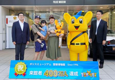 　警察博物館「ポリスミュージアム」の４００万人目の来館者となり、記念撮影する川上謙太さん（左から２人目）ら家族。璃空ちゃんはご機嫌ななめ＝１７日午前、東京都中央区