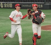 天理大×中部学院大＝延長１１回表、無失点で切り抜けハイタッチする中部学院大の２番手縄田（左）と捕手竹中＝東京ドーム