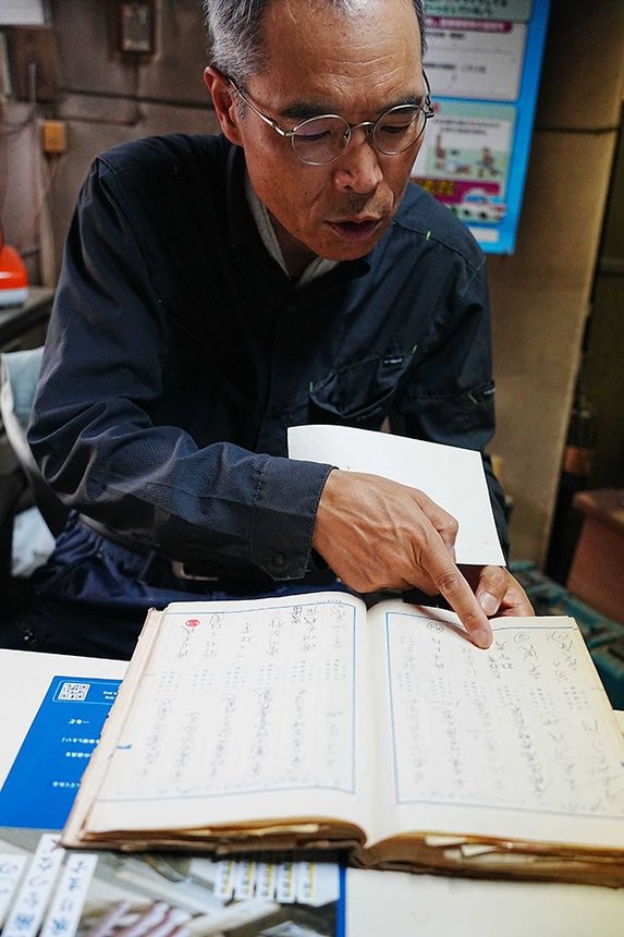 昭和から平成初期にかけての帳簿を見る出立浩之さん＝京都府舞鶴市