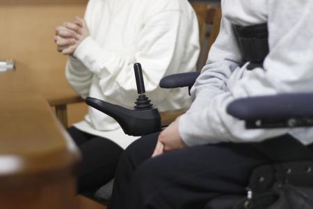 　３月、私立高校入試を巡り取材に応じる車いすの生徒（手前）と保護者＝香川県内