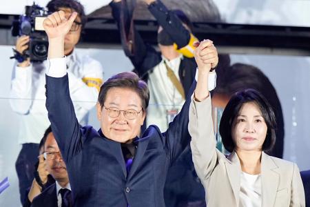 　韓国大統領選で当選を確実にし、支持者の前で両手を上げる「共に民主党」の李在明前代表＝４日未明、ソウルの国会前（共同）