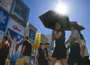 　猛暑日となった大阪・ミナミの繁華街で、日傘を差して歩く人たち。気象庁は夏（６〜８月）の平均気温が１８９８年の統計開始以降で最高になったと発表した＝１日午後