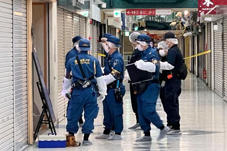　窃盗事件があった「中野ブロードウェイ」にある時計店付近を調べる捜査員ら＝２９日夜、東京都中野区
