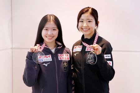 　ＧＰ第３戦スケートカナダから帰国し、メダルを手に撮影に応じる千葉百音（右）と中井亜美＝３日、羽田空港