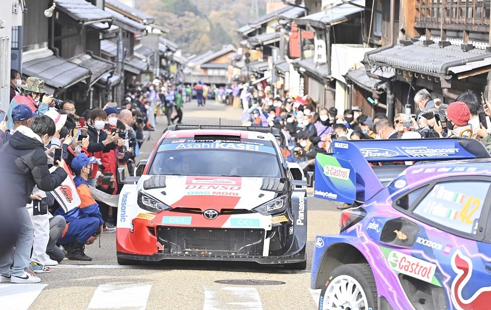 今月行われたラリージャパンで、リエゾンで岩村本通りの町並みを通り抜けるラリーカー＝１３日、恵那市岩村町