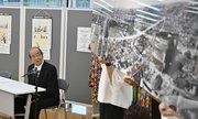 式典で焼け跡の写真を解説する岐阜空襲を記録する会の篠崎喜樹代表＝９日午前１０時８分、岐阜市役所