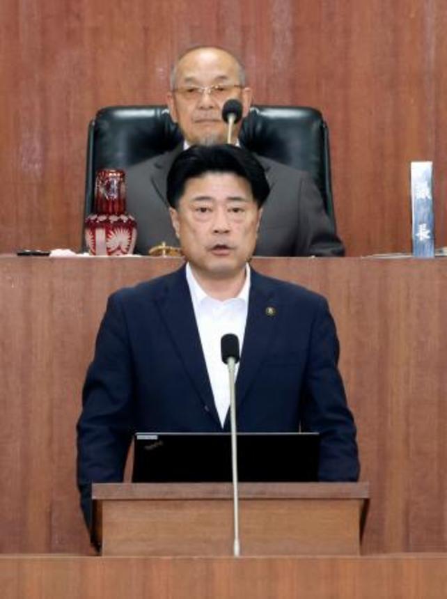 　福岡県田川市議会の臨時の本会議で発言する村上卓哉市長（手前）＝２９日午前