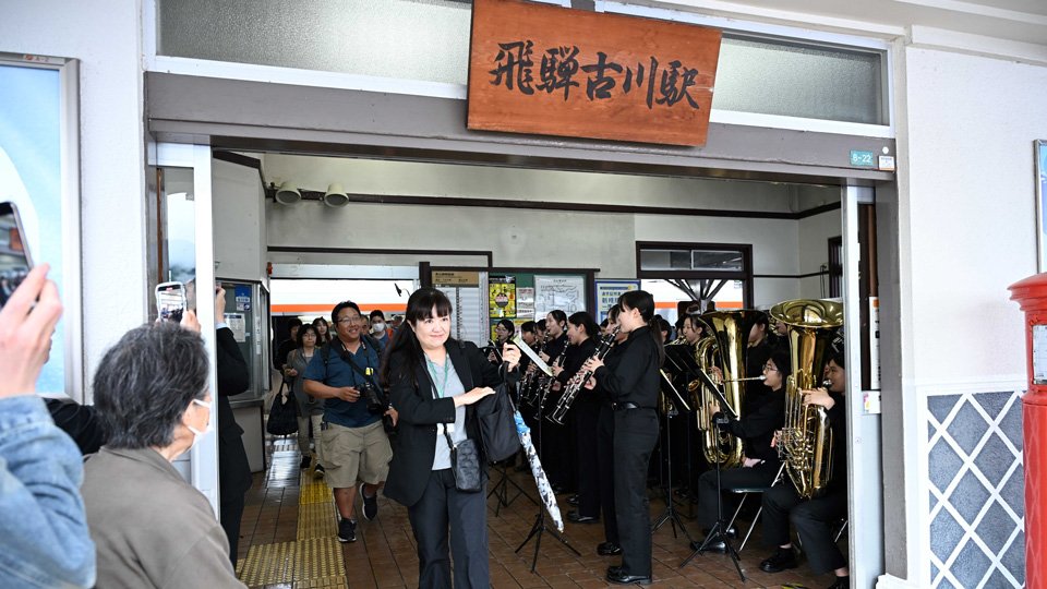 吹奏楽の演奏で出迎えられた記念列車の観光客ら＝飛騨市古川町金森町、ＪＲ飛騨古川駅