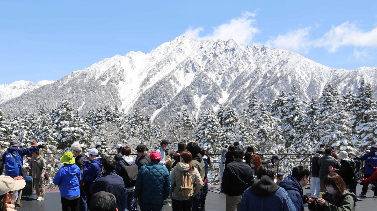 残雪の北アルプスの眺望を楽しむ観光客ら＝高山市奥飛騨温泉郷、新穂高ロープウェイ西穂高口駅展望台